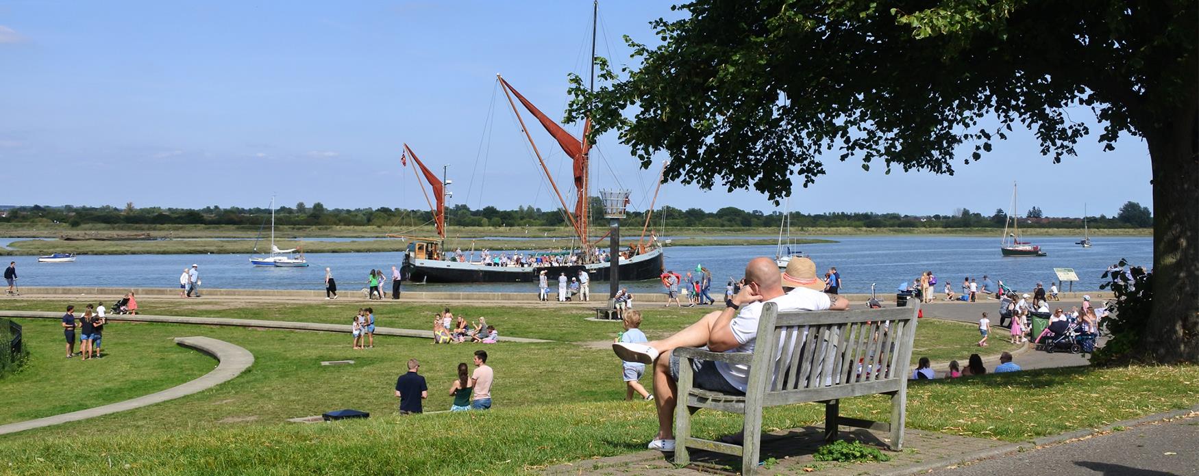 People sitting in the park, with the river Blackwater in the background