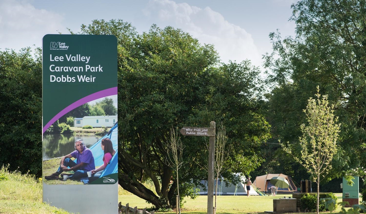 front entrance sign for Lee Valley Caravan Park Dobb Weir located on a  grassy bank