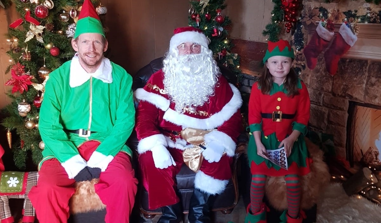 Father Christmas and his elves sitting in his grotto