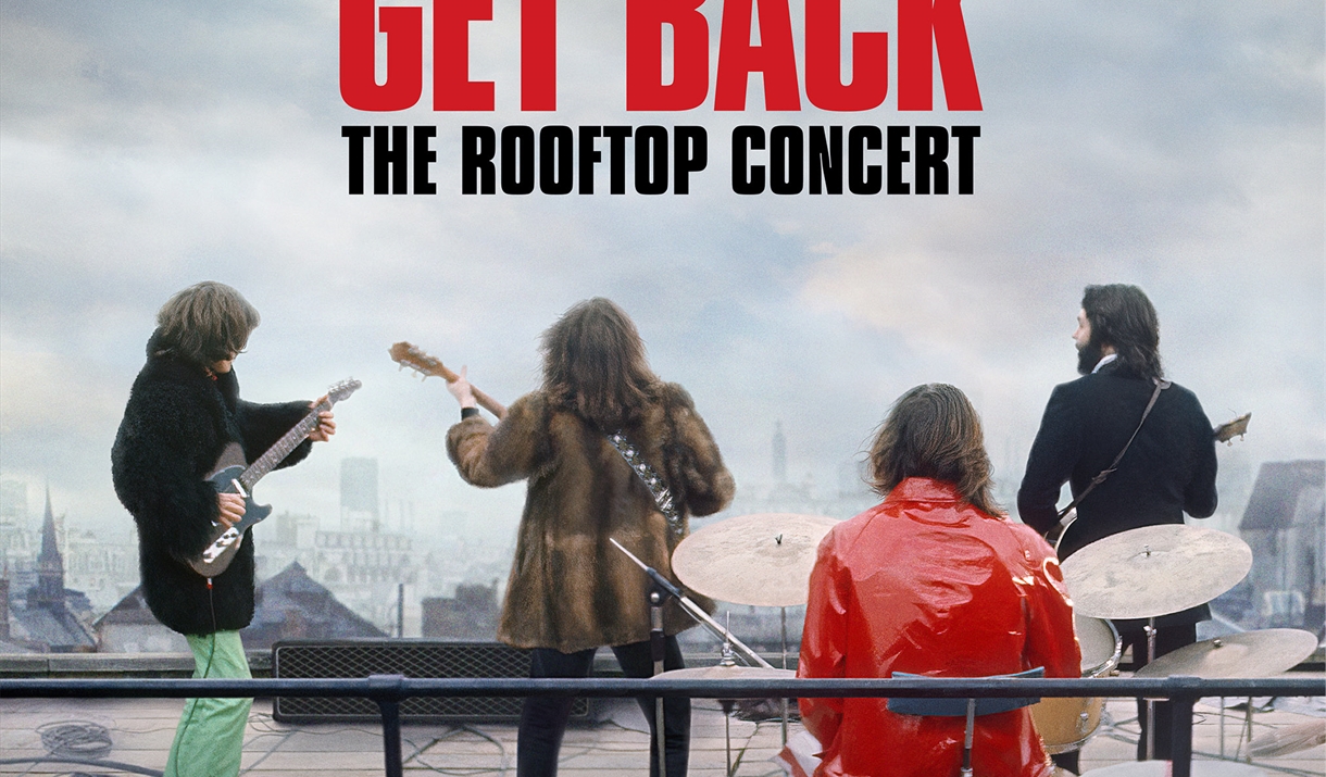 Image of The Beatles on a roof top playing guitar and drums