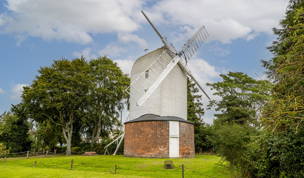 Bocking Windmill in spring with green grass in front and blue skies behind