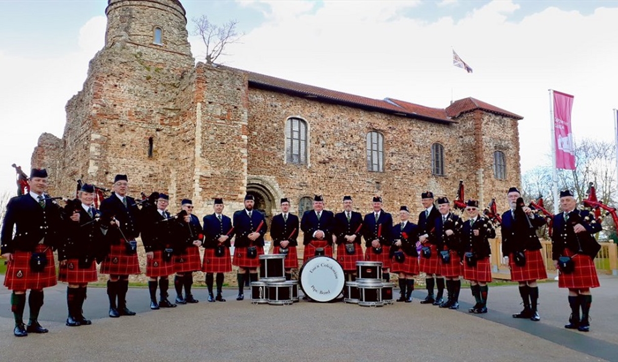 The Essex Caledonian Pipe Band pose in full tartan, outside Colchester Castle.