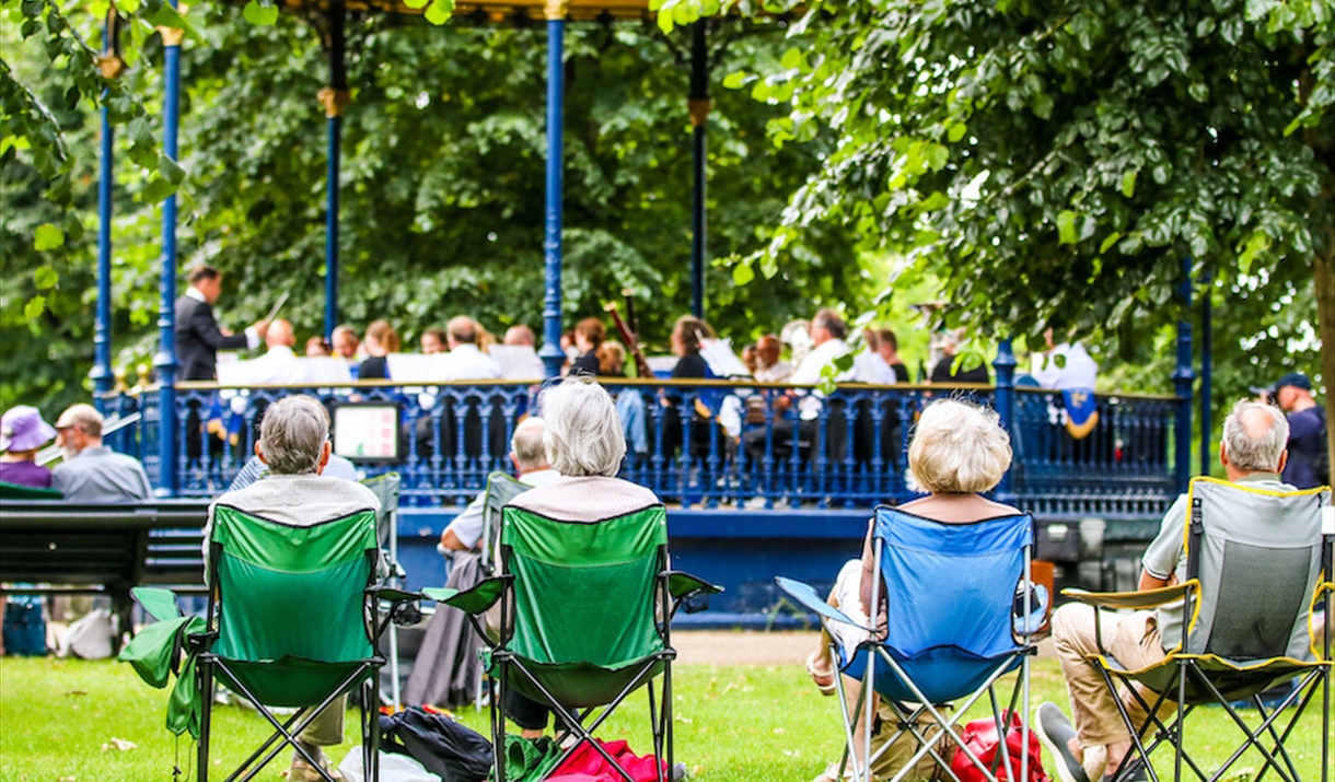 Audience on camping chairs watching a bandstand concert