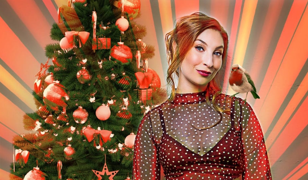 Jess Robinson in front of a Christmas Tree