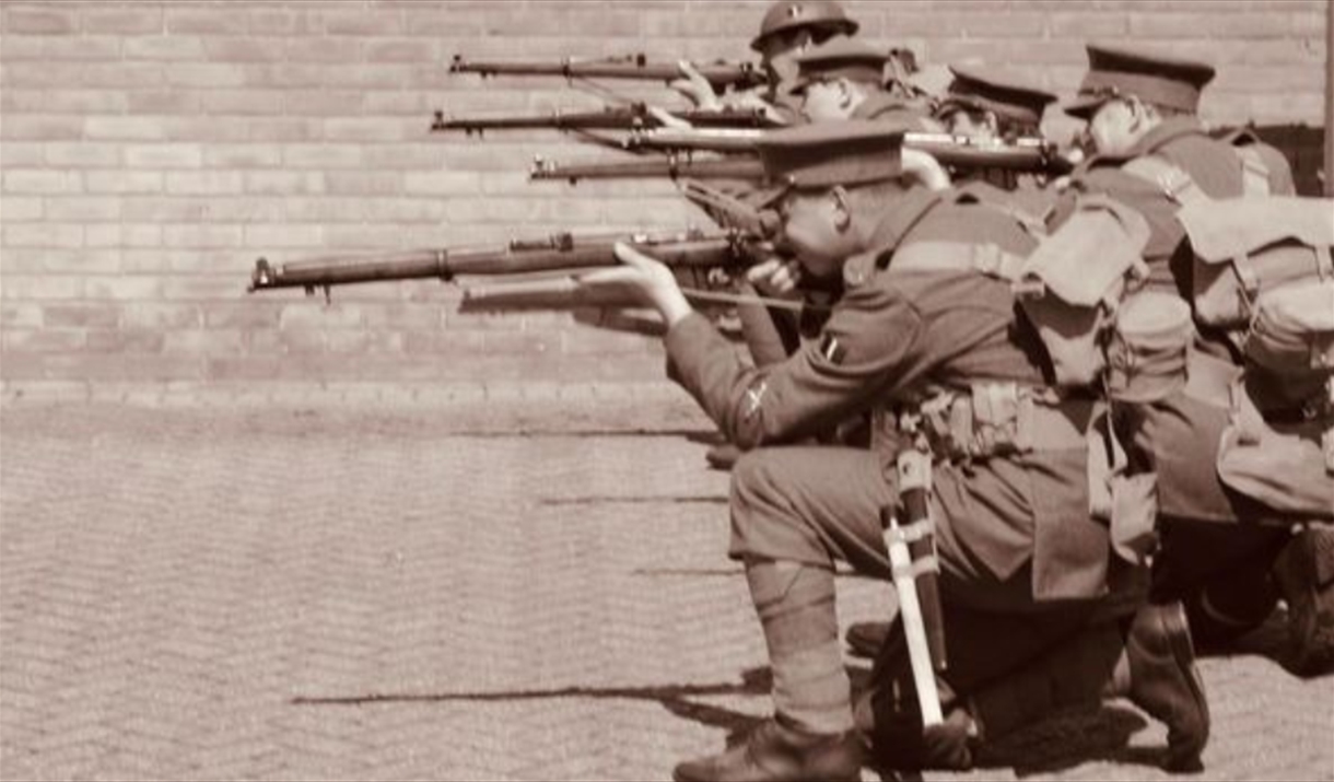 10th Essex Battalion WWI Re-enactment Group dressed as World War 1 soldiers, crouching down to fire their rifles in a line