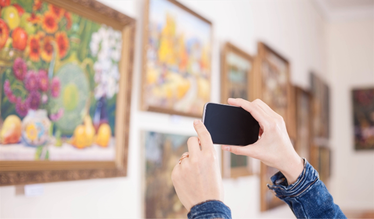Person taking photos at an art exhibition
