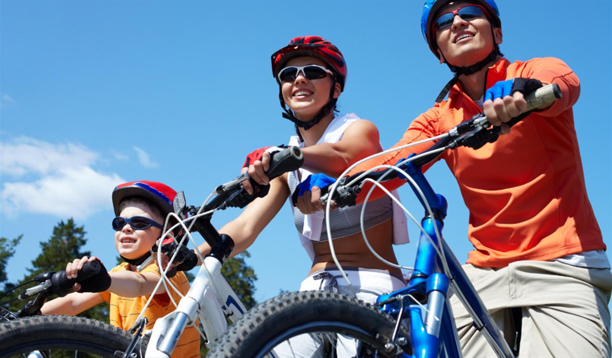 A child and two adults riding on bicycles