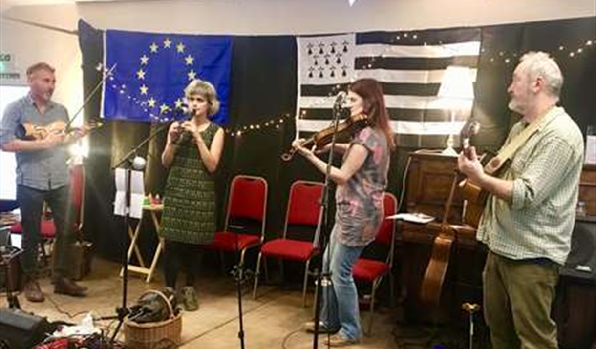 Four musicians playing in front of the EU Flag