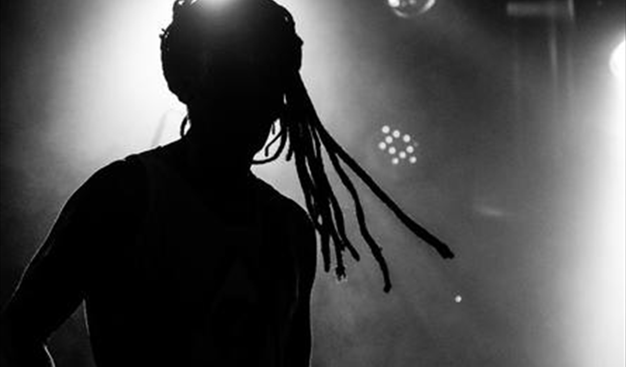 A silhouette of a man with dreadlocks