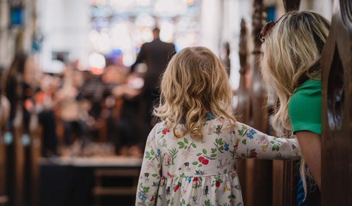 A toddler watches an Orchestra play