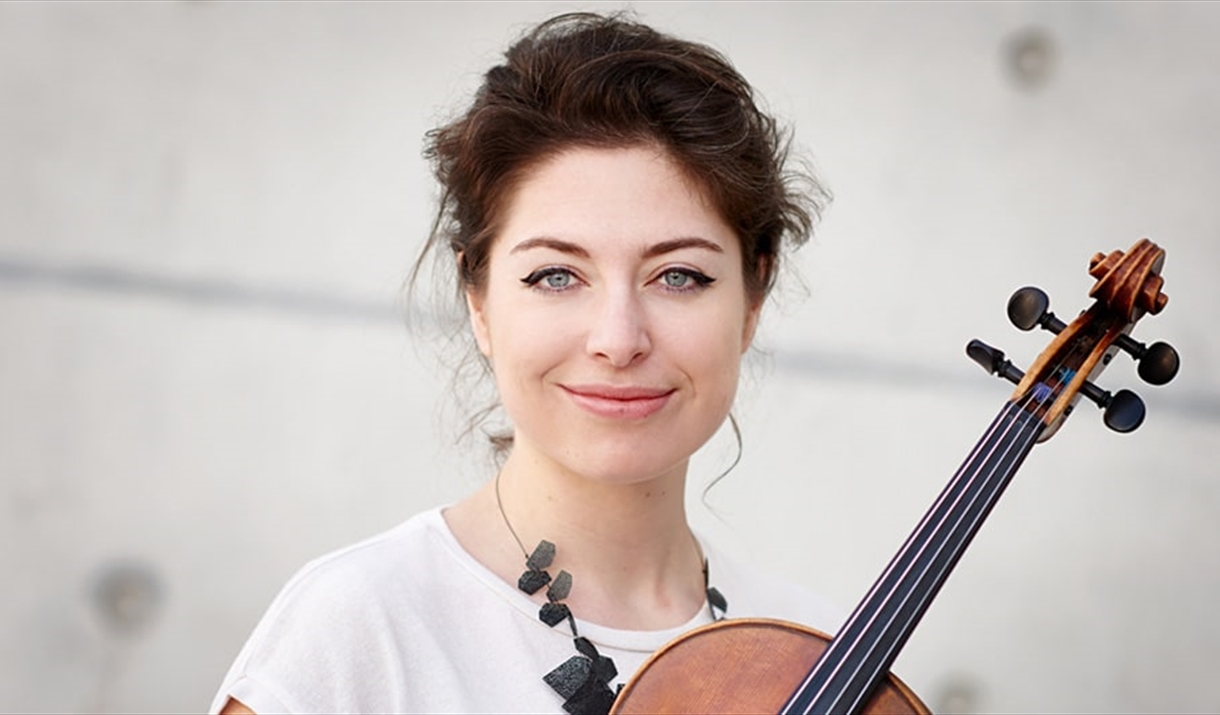 A female musician poses with her violin