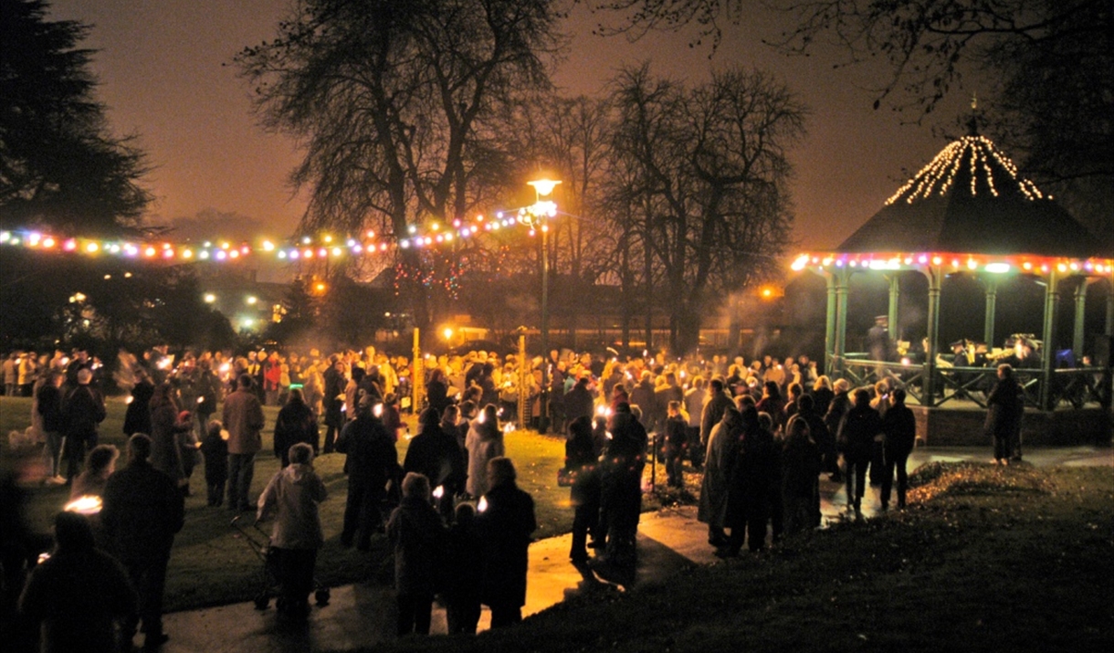 Halstead Christmas Light Switch on event with people around the bandstand at Halstead Public Gardens - Image