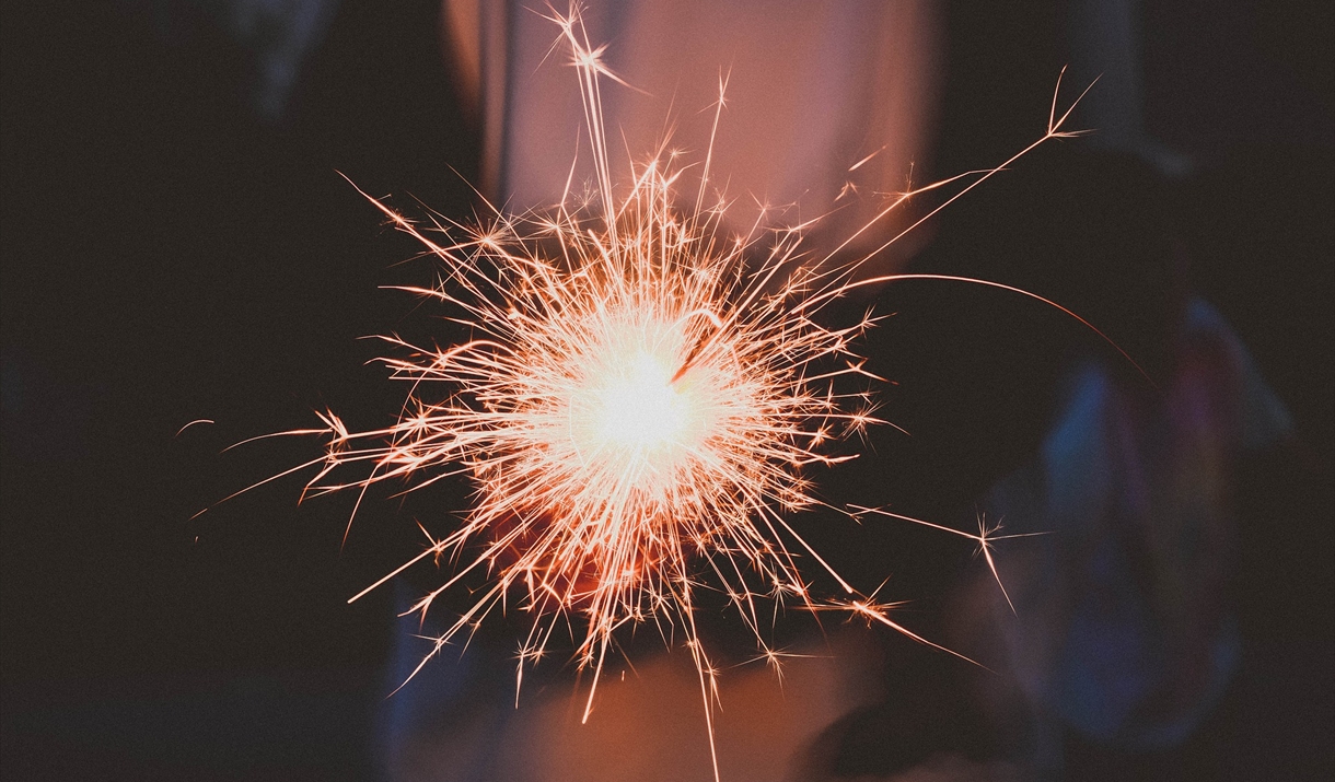 Sparkler glowing pink on firework night