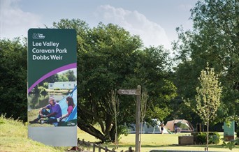 front entrance sign for Lee Valley Caravan Park Dobb Weir located on a  grassy bank