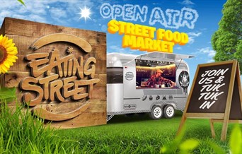 an image of a food truck in a park, a wooden sign reads 'Eating Street', text in the sky reads 'Open Air Street Food Market'