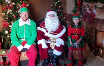 Father Christmas and his elves sitting in his grotto