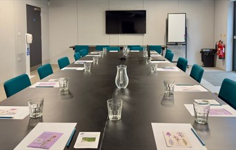 Photograph of a meeting room set up in a boardroom style.