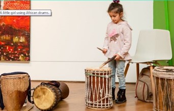 A young girl playing he drums