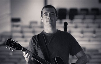 Chris Allard holding a guitar