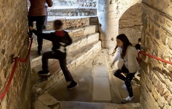 Children climbing up a stone spiral staircase