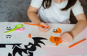 A child colours in pumpkins