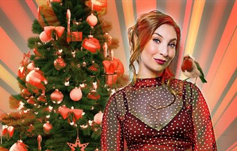 Jess Robinson in front of a Christmas Tree