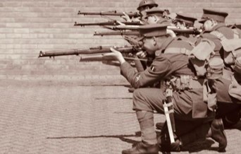 10th Essex Battalion WWI Re-enactment Group dressed as World War 1 soldiers, crouching down to fire their rifles in a line
