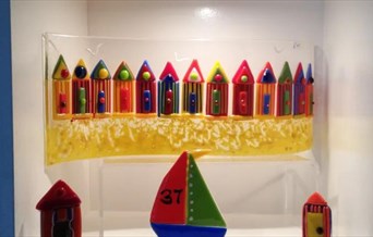 Fused glass in the shape of beach huts and boats by Ania Originals