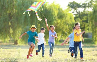 Children flying kites in a park