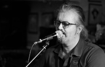 Folk singer Dan Fraser singing, moody black and white photo