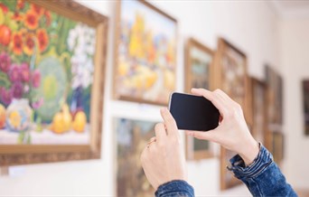 Person taking photos at an art exhibition