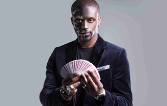 A man holds up a deck of cards