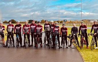 A group of cyclists in a line, wearing club shirts.
