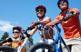 A child and two adults riding on bicycles