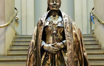 Living bronze statute of Queen Victoria in front of steps.