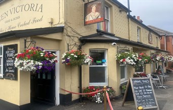 Picture of the public house from outside with hanging baskets and entrance