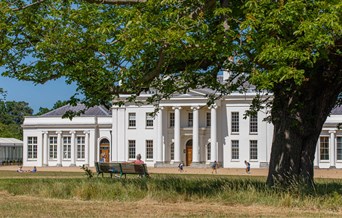 The exterior of Hylands House with people enjoying the front lawn.