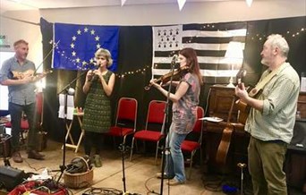 Four musicians playing in front of the EU Flag