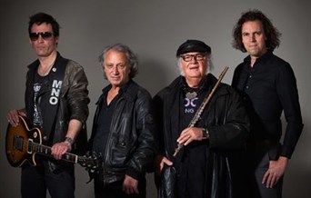 Four black-clad members of focus. One holds a guitar, another holds a flute.