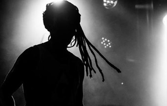 A silhouette of a man with dreadlocks