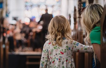 A toddler watches an Orchestra play