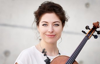 A female musician poses with her violin