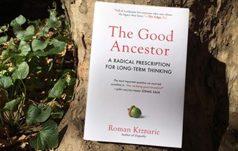 A copy of "The Good Ancestor" propped against a tree