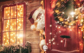 Santa pokes his head out of a door