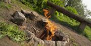 logs burning in stone fire pit area