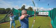 A couple participating in archery at Potters Resorts Five Lakes