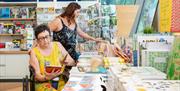 Two customers browse products in the Firstsite shop