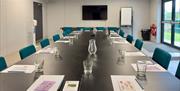 Photograph of a meeting room set up in a boardroom style.