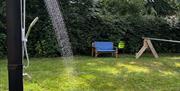 Outdoor shower at Galloping Grind set on a wooden platform in a grassy area, surrounded by trees