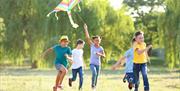 Children flying kites in a park